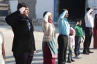 Directors singing national anthem with family